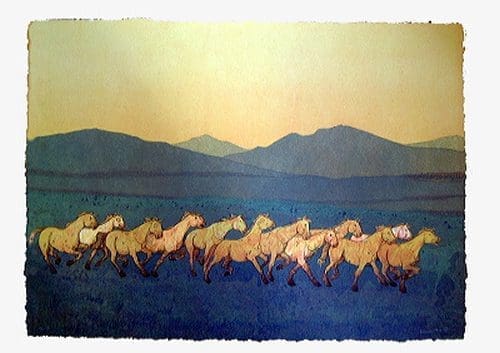 Wild horses running against mountain backdrop
