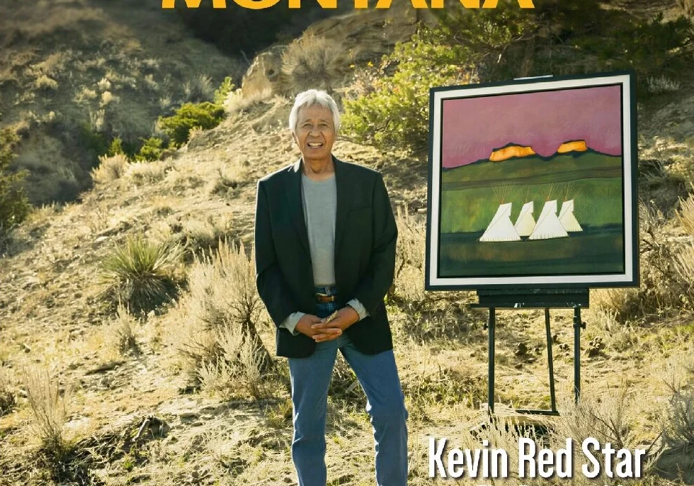 Man standing on a rocky hill with a colorful painting of white birds beside him.